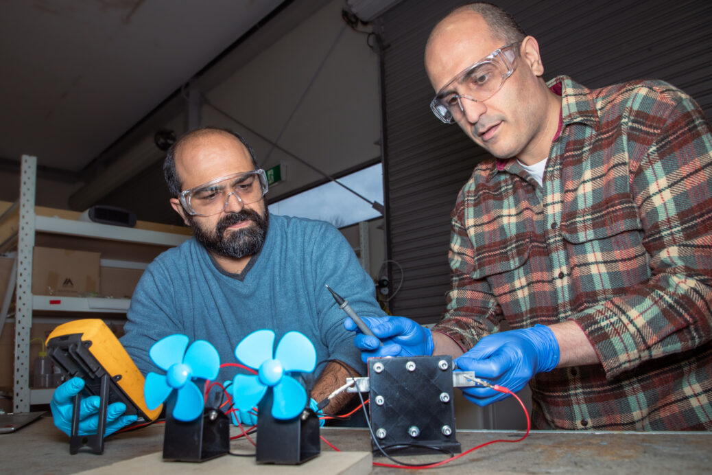 Shahin Heidari (left) and Seyed Niya (right) with the proton battery operating two small fans in the RMIT lab